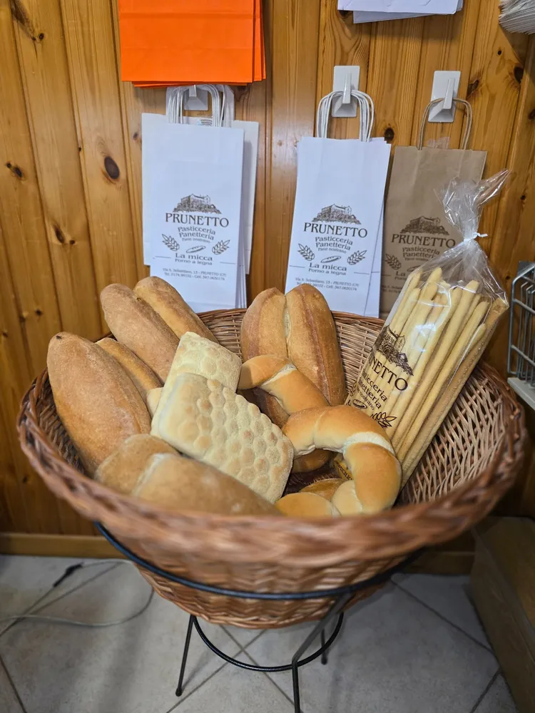 Cesto di vimini con pane, panini e grissini nei sacchetti della panetteria