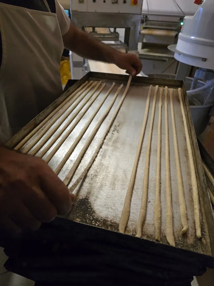 Teglia di grissini stesi a mano pronti per la cottura
