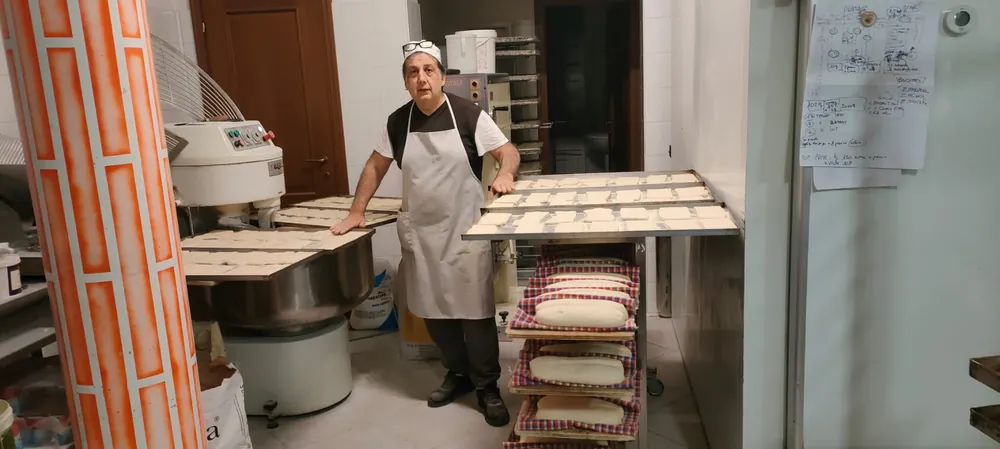 Ruben nel laboratorio con le teglie di impasto